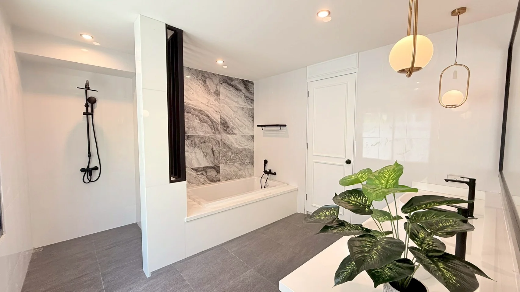 A custom bathroom with marble feature wall and brass fixtures